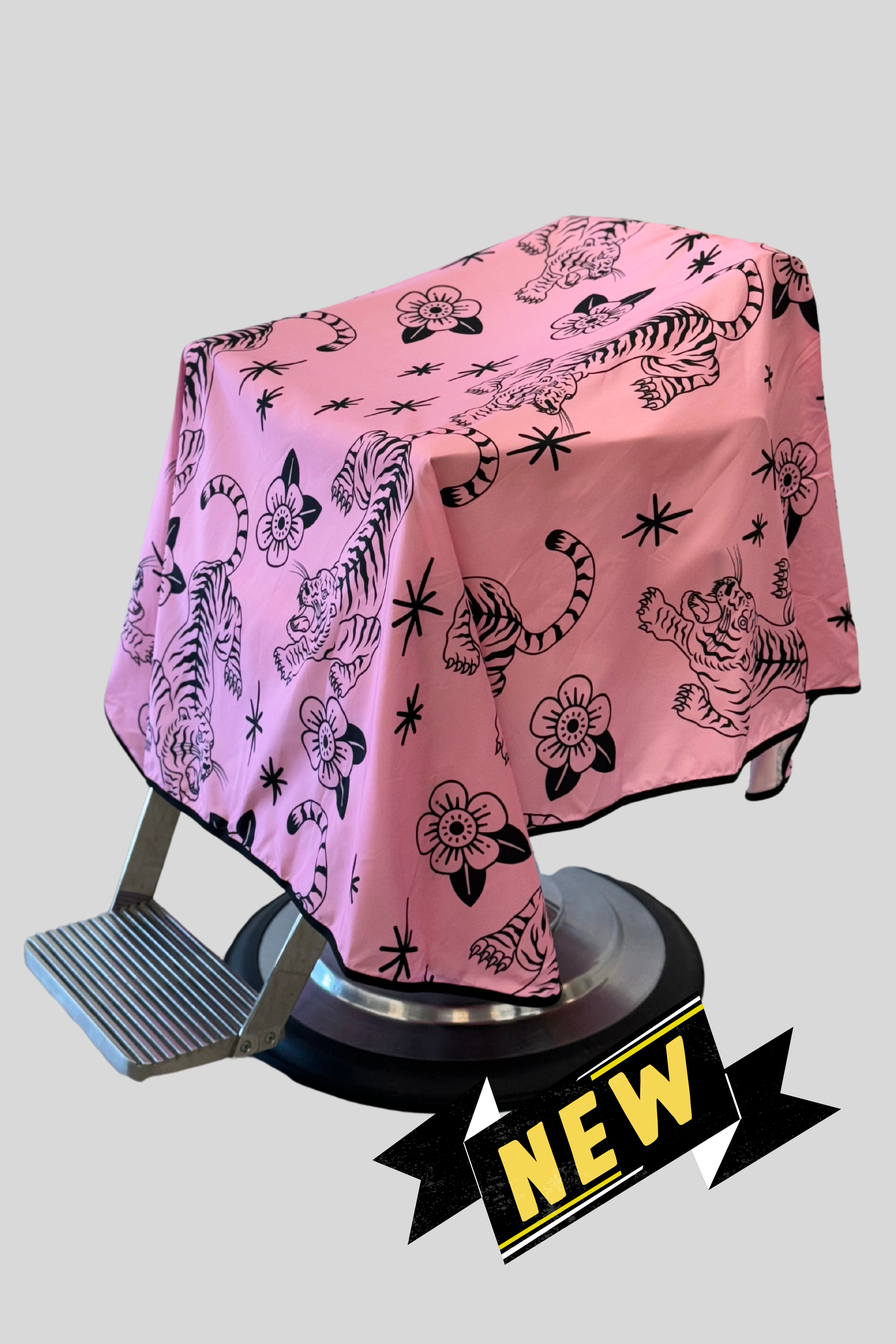 pink and black tora barber cape with "new" banner